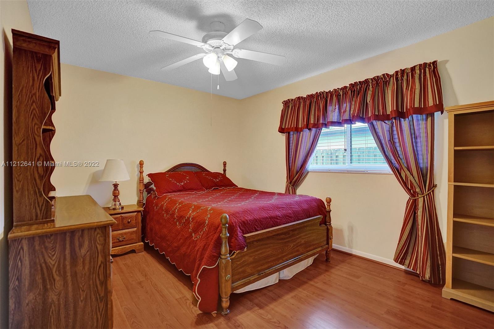 7420 Southwest 15th Street Plantation, FL 33317 - Photo 29 of 60 a spacious bedroom with a bed and a window