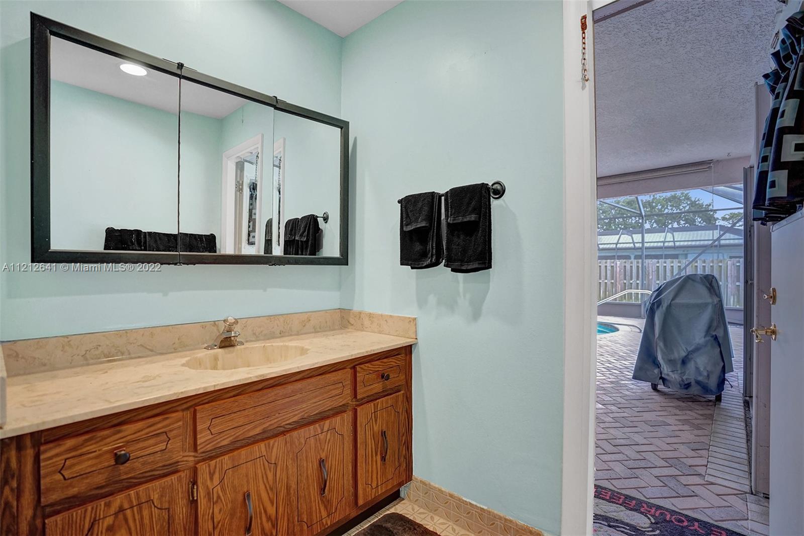 7420 Southwest 15th Street Plantation, FL 33317 - Photo 34 of 60 a bathroom with a sink and a mirror