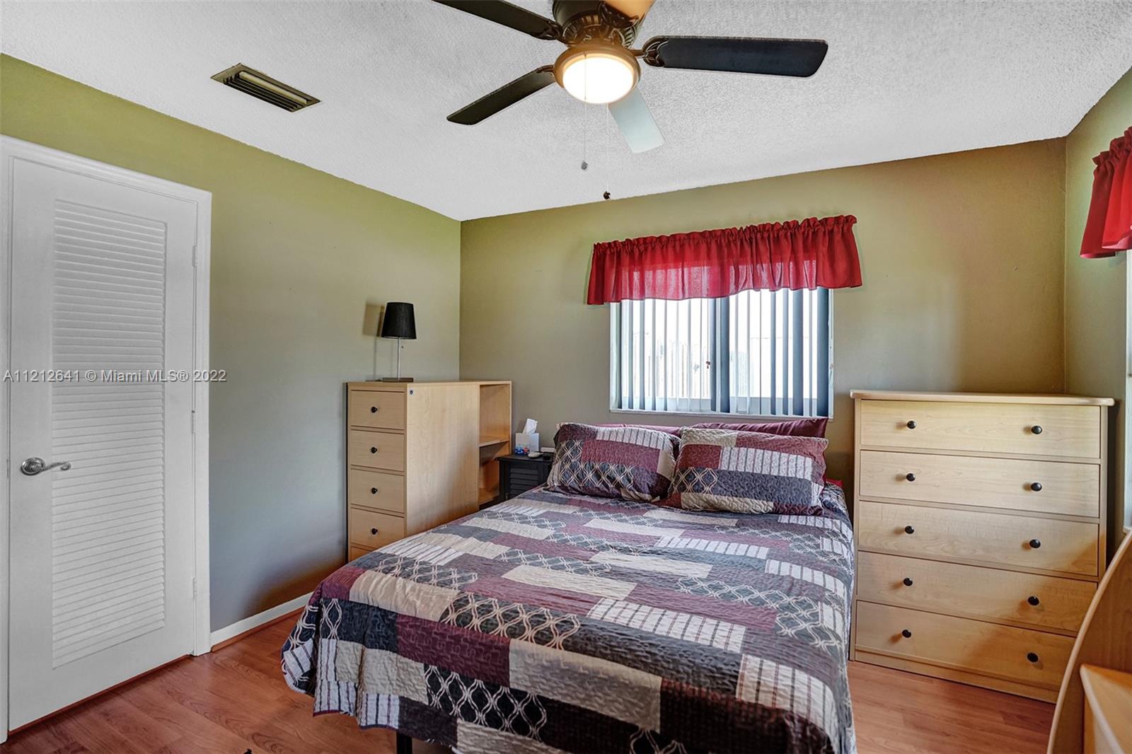 7420 Southwest 15th Street Plantation, FL 33317 - Photo 37 of 60 a bedroom with a bed and a dresser