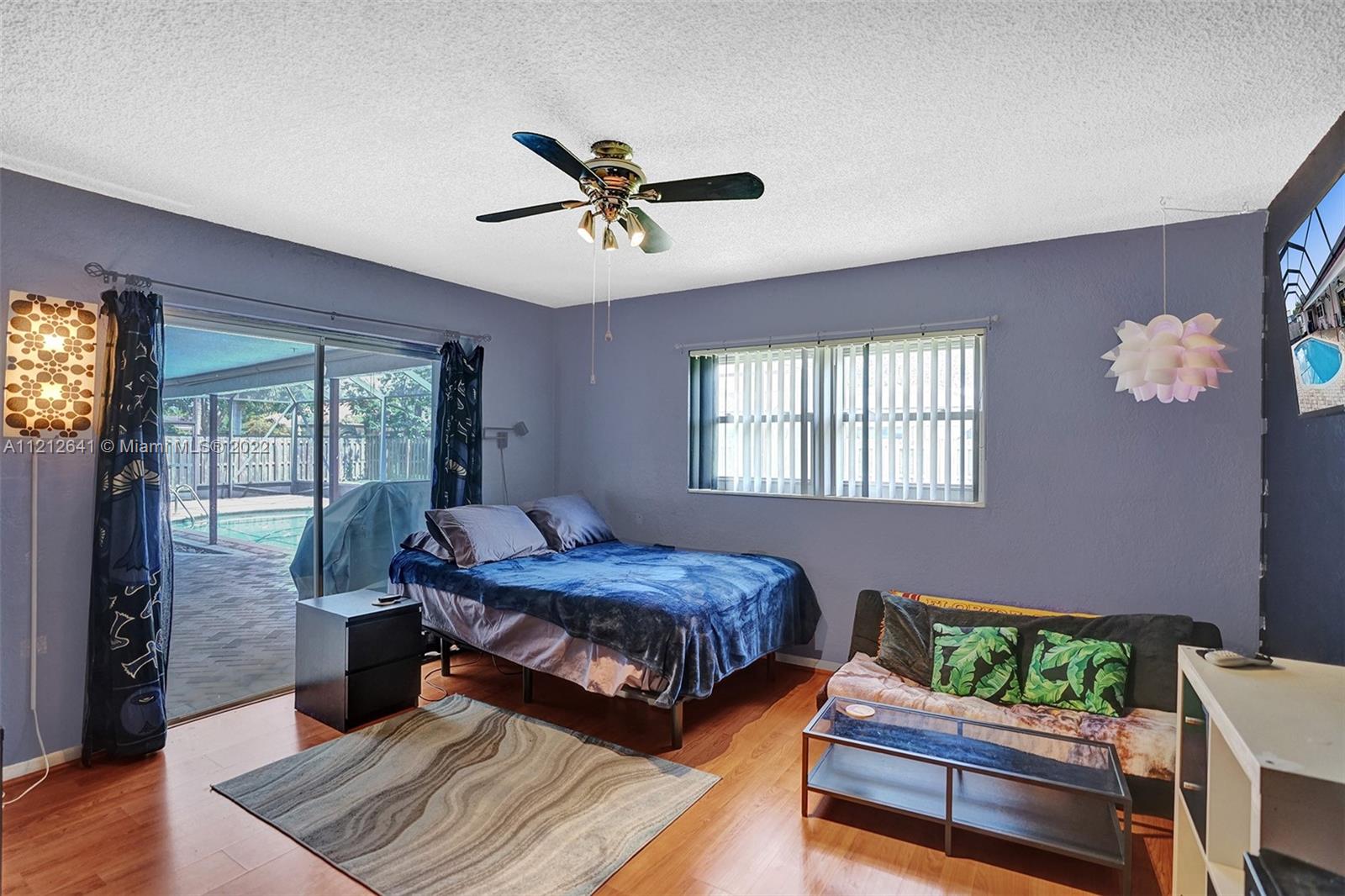 7420 Southwest 15th Street Plantation, FL 33317 - Photo 39 of 60 a bedroom with a bed and wooden floor