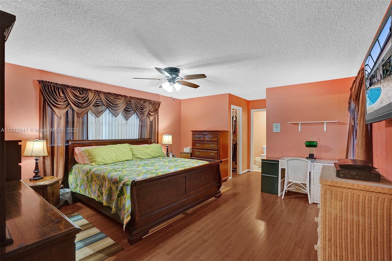 7420 Southwest 15th Street Plantation, FL 33317 - Photo 41 of 60 a bedroom with a bed and a chandelier