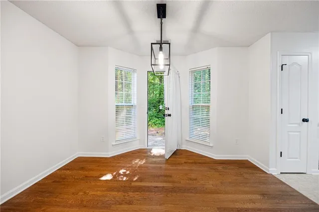 a view of a livingroom with wooden floor and windows