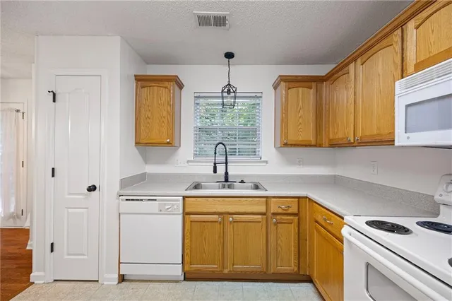 a kitchen with stainless steel appliances granite countertop a sink cabinets and a window
