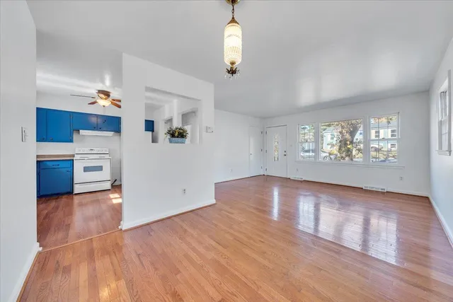 a view of an empty room with a window and wooden floor