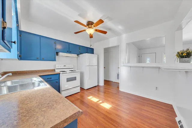 a kitchen with granite countertop a stove a sink and a refrigerator