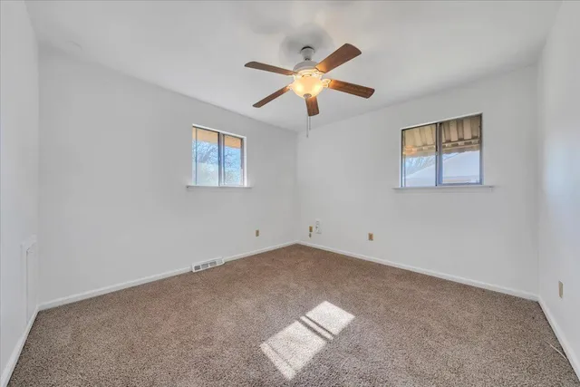 a view of room with hardwood floor and ceiling fan