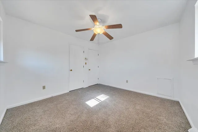 an empty room with closet and windows