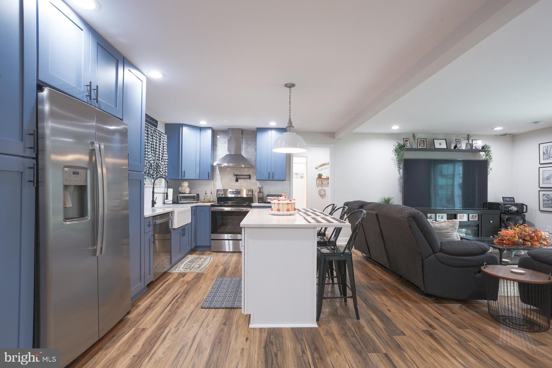 6 Hickory Lane Levittown, PA 19055 - Photo 14 of 32 a kitchen with stainless steel appliances granite countertop a refrigerator a oven a stove and a dining table with wooden floor
