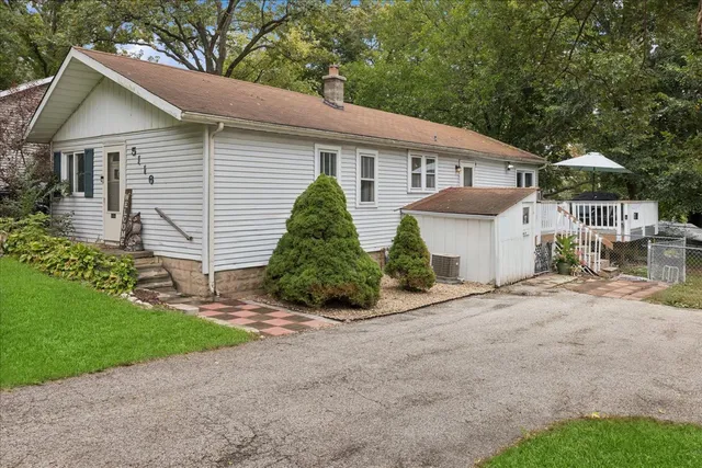 a front view of a house with a garden and plants