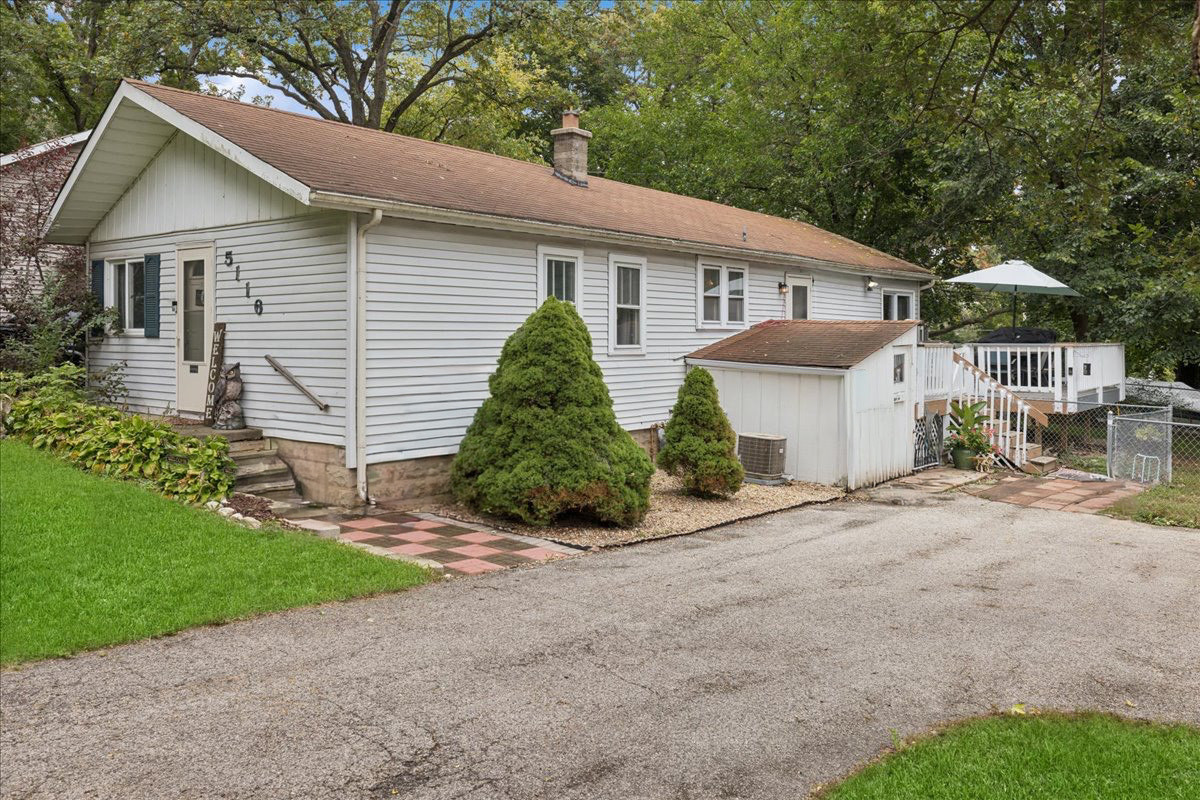 a front view of a house with a garden and plants