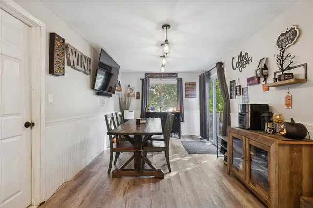 a view of a dining room with furniture a chandelier and wooden floor