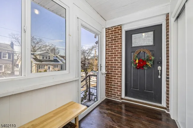 a view of a hallway with wooden floor and a window