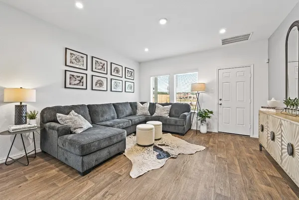 a living room with furniture and wooden floor