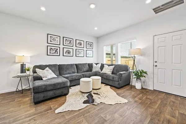 a living room with furniture and wooden floor