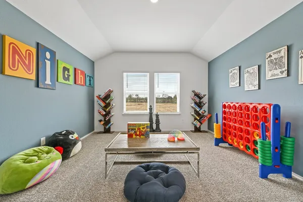 a living room with furniture and a baby crib