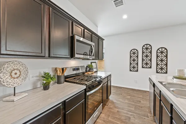 a kitchen with stainless steel appliances a stove a microwave and a refrigerator