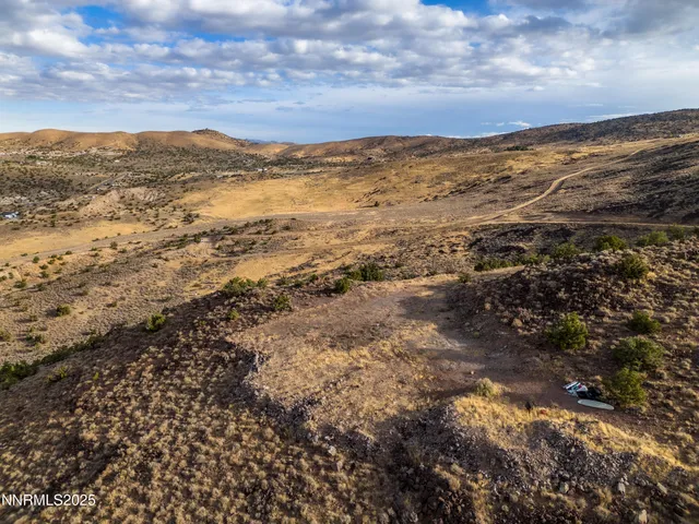 a view of a field with mountains in the background