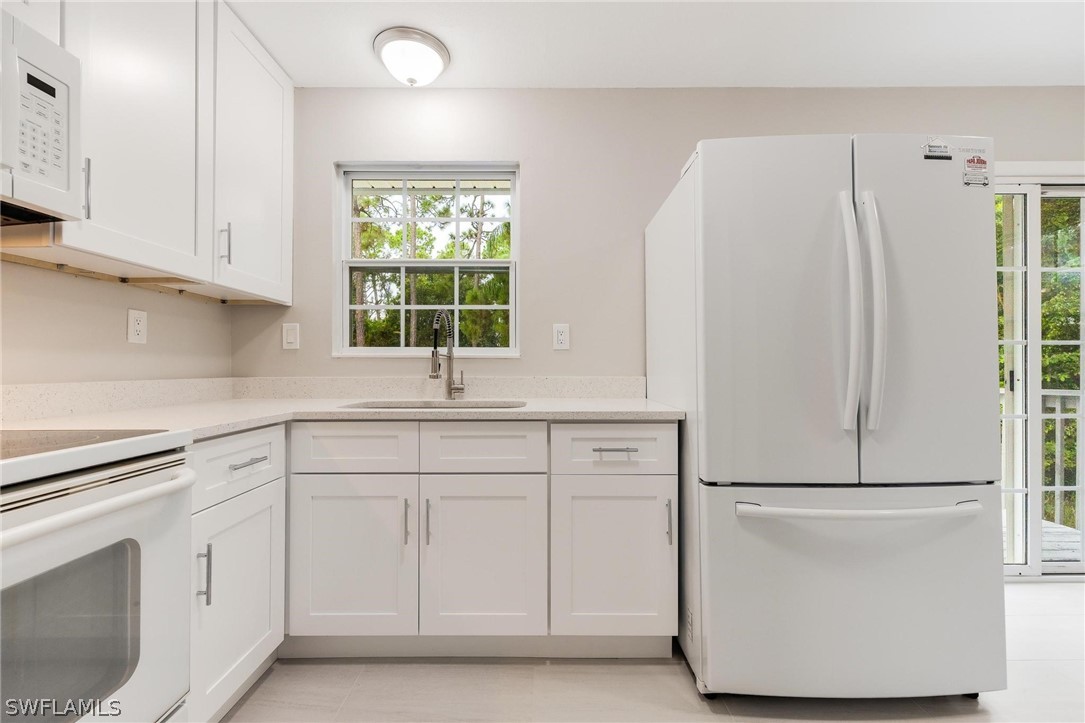18804 Matanzas Road Fort Myers, FL 33967 - Photo 15 of 19 a kitchen with white cabinets and white appliances