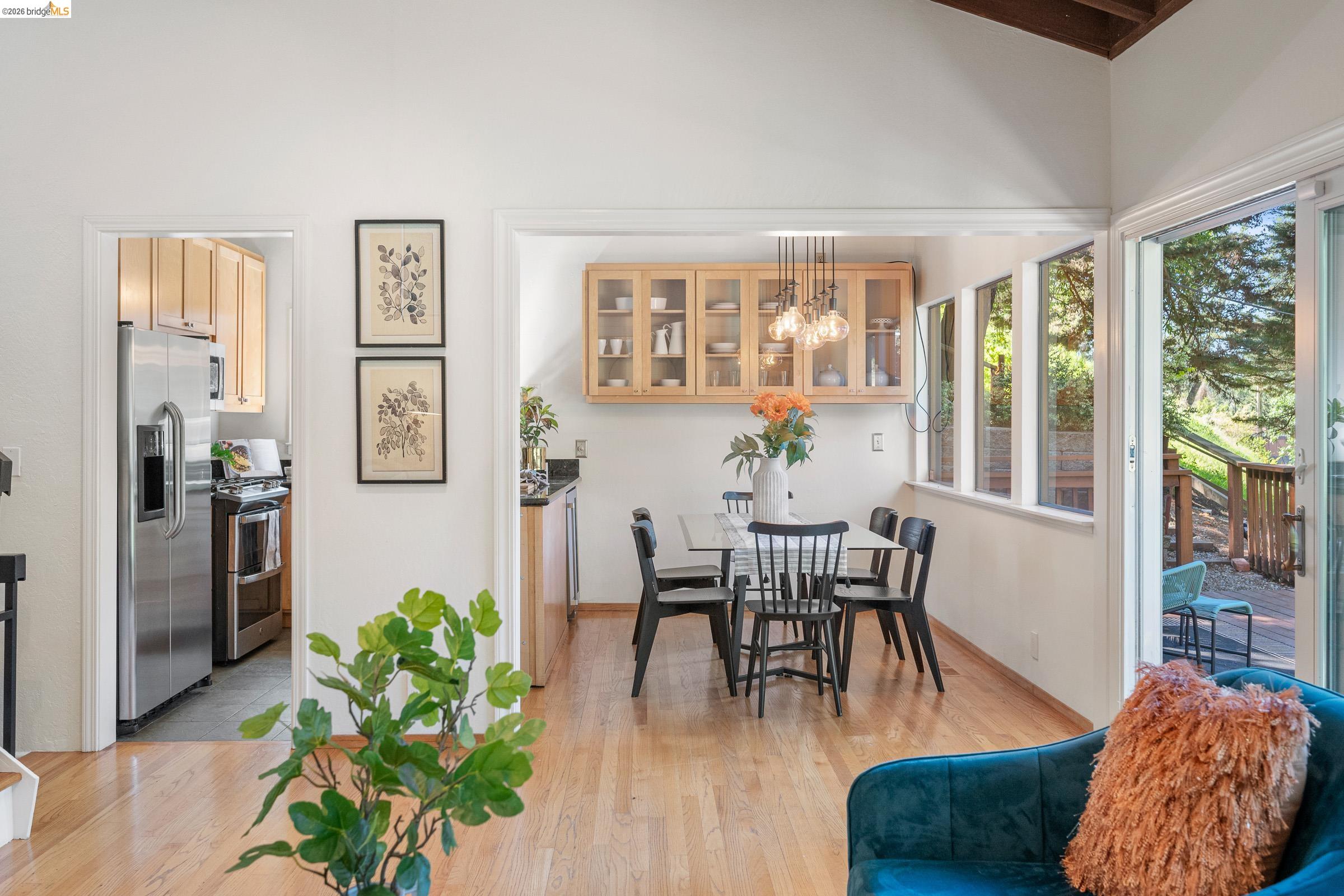 6600 Heather Ridge Way Oakland, CA 94611 - Photo 12 of 66 Bright dining area featuring wood-finish flooring, built-in display cabinetry, a contemporary multi-light fixture, and multiple windows