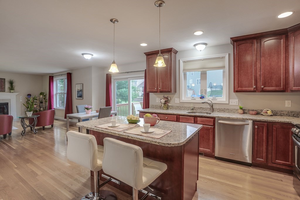 68 Diamondback Avenue Nashua, NH 03062 - Photo 3 of 22 a kitchen with granite countertop sink stove dining table and chairs