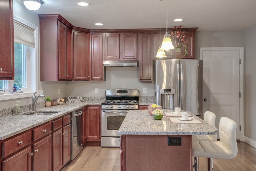 68 Diamondback Avenue Nashua, NH 03062 - Photo 4 of 22 a kitchen with stainless steel appliances granite countertop a sink stove and refrigerator
