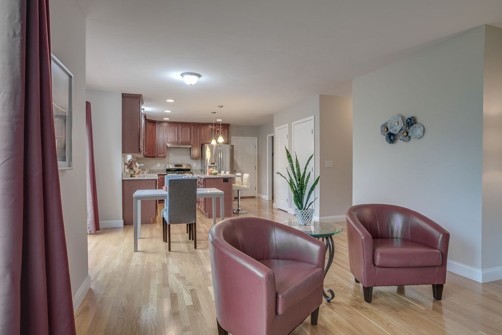 68 Diamondback Avenue Nashua, NH 03062 - Photo 5 of 22 a living room with furniture a potted plant and kitchen view