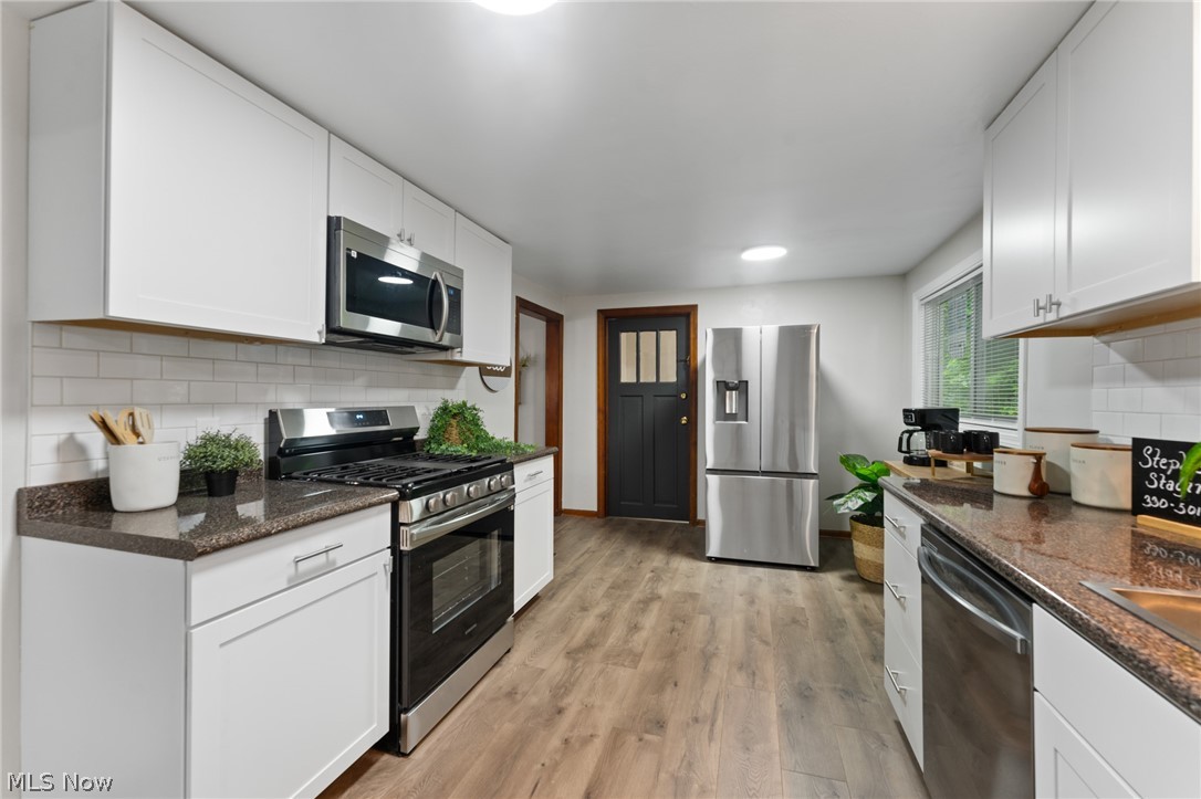 3568 McCartney Road Youngstown, OH 44505 - Photo 13 of 29 Kitchen with stainless steel appliances, white cabinetry, light hardwood / wood-style flooring, and tasteful backsplash