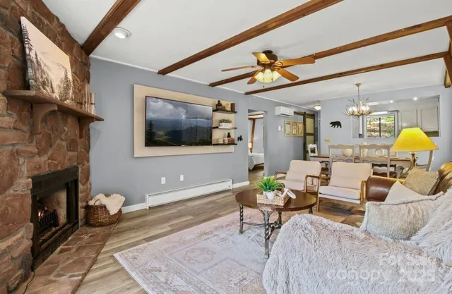 a living room with furniture a flat screen tv and a fireplace