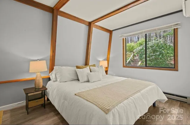 a bedroom with a bed lamp and a large window