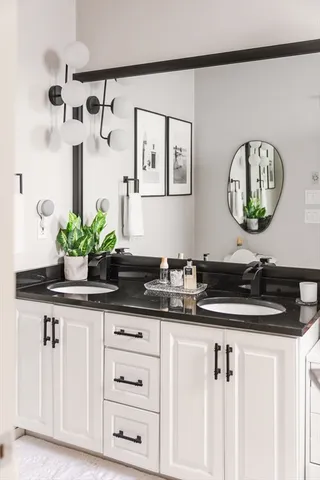 a bathroom with a granite countertop sink a mirror and vanity
