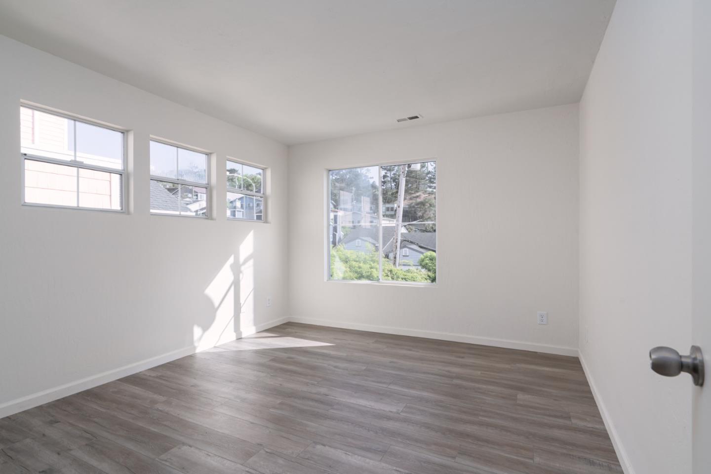 435 Norfolk Drive Pacifica, CA 94044 - Photo 15 of 28 an empty room with wooden floor and windows