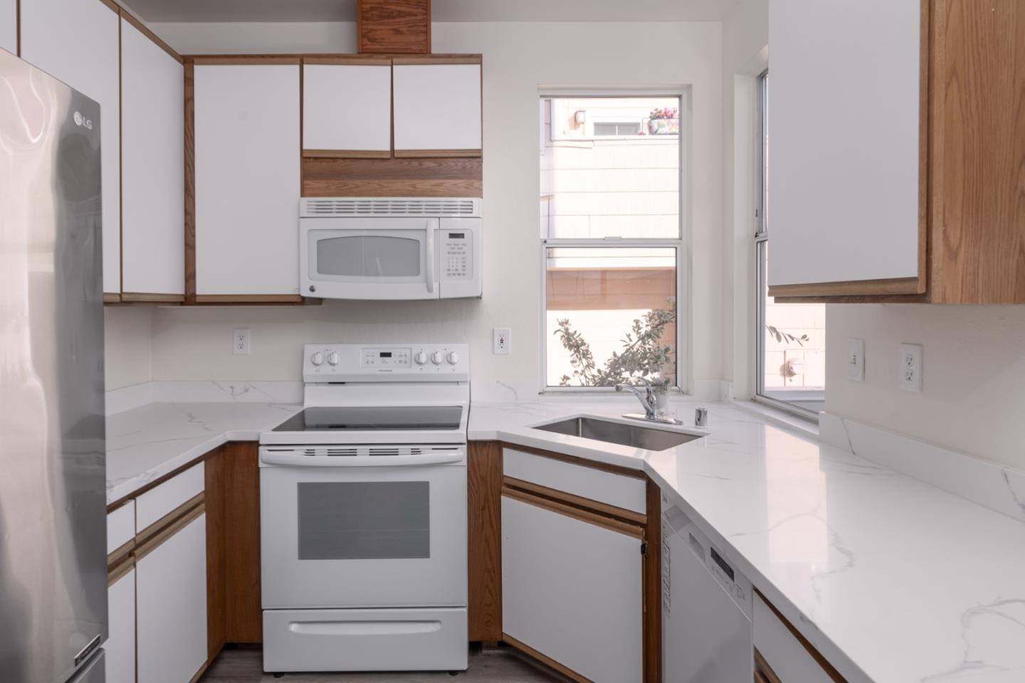 435 Norfolk Drive Pacifica, CA 94044 - Photo 5 of 28 a kitchen with stainless steel appliances white cabinets and a stove top oven