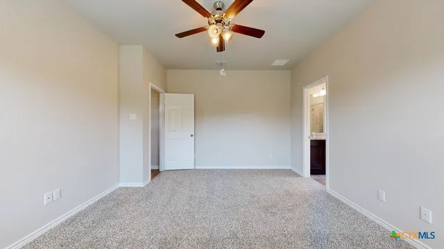 an empty room with closet and a chandelier fan
