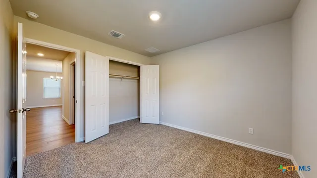 an empty room with wooden floor and a bathroom