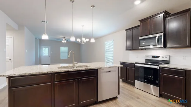 a kitchen with stainless steel appliances granite countertop a sink a stove and oven