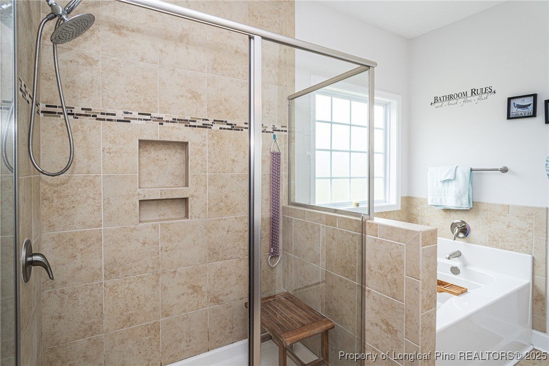 8220 Rivermist Lane Linden, NC 28356 - Photo 26 of 44 a bathroom with a bathtub and a shower