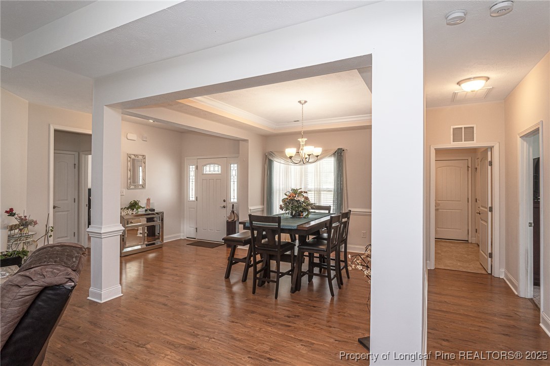 8220 Rivermist Lane Linden, NC 28356 - Photo 7 of 44 a view of a dining room and livingroom with furniture wooden floor a chandelier