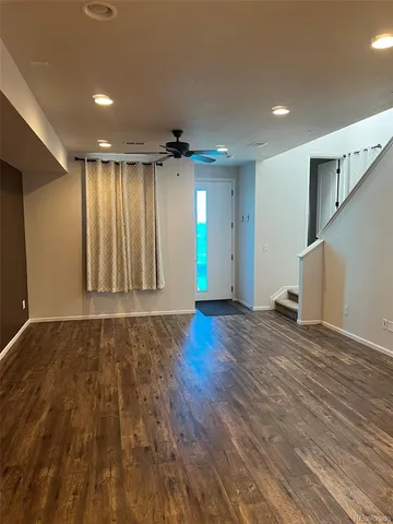 a view of an empty room with wooden floor