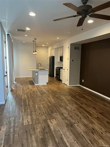 a view of a kitchen with a sink and wooden floor