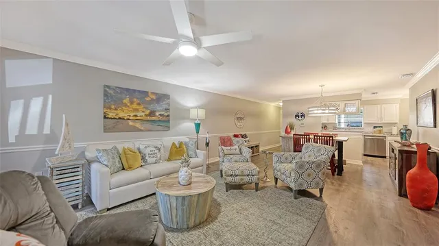 a living room with furniture kitchen view and a chandelier