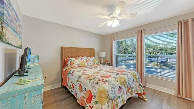 a bedroom with a bed and a flat tv screen on dresser