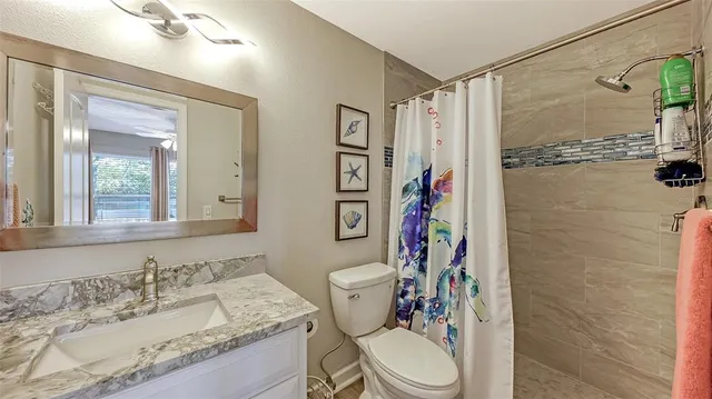 a bathroom with a granite countertop toilet sink and shower