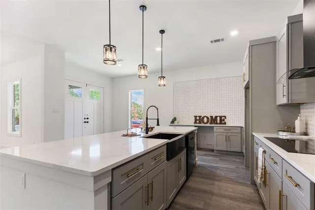 a kitchen with stainless steel appliances granite countertop a sink a stove and a refrigerator