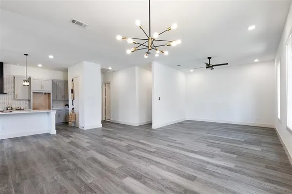 wooden floor in an empty room with a kitchen