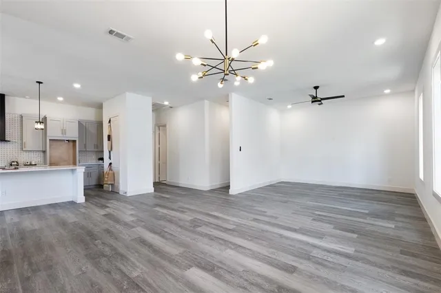 wooden floor in an empty room with a kitchen