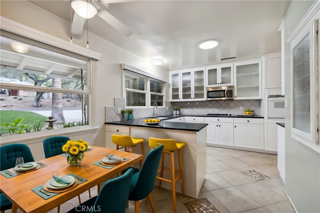 4254 Miramonte Place Riverside, CA 92501 - Photo 12 of 43 a kitchen with a stove a sink a dining table and chairs