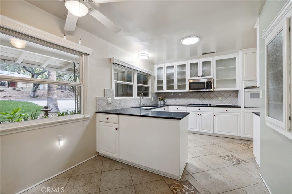 4254 Miramonte Place Riverside, CA 92501 - Photo 13 of 43 a kitchen with stainless steel appliances granite countertop a sink and dishwasher a stove top oven with wooden floor