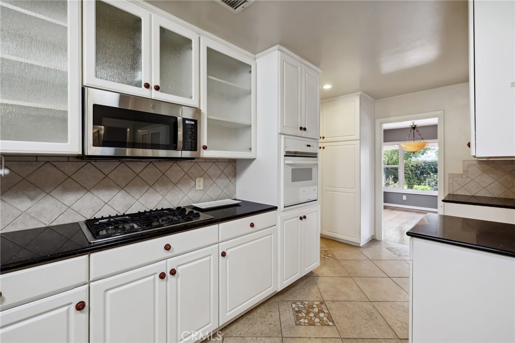 4254 Miramonte Place Riverside, CA 92501 - Photo 16 of 43 a kitchen with cabinets stainless steel appliances and a window