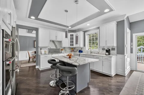 a open kitchen with stainless steel appliances granite countertop a lot of counter space dining table and chairs