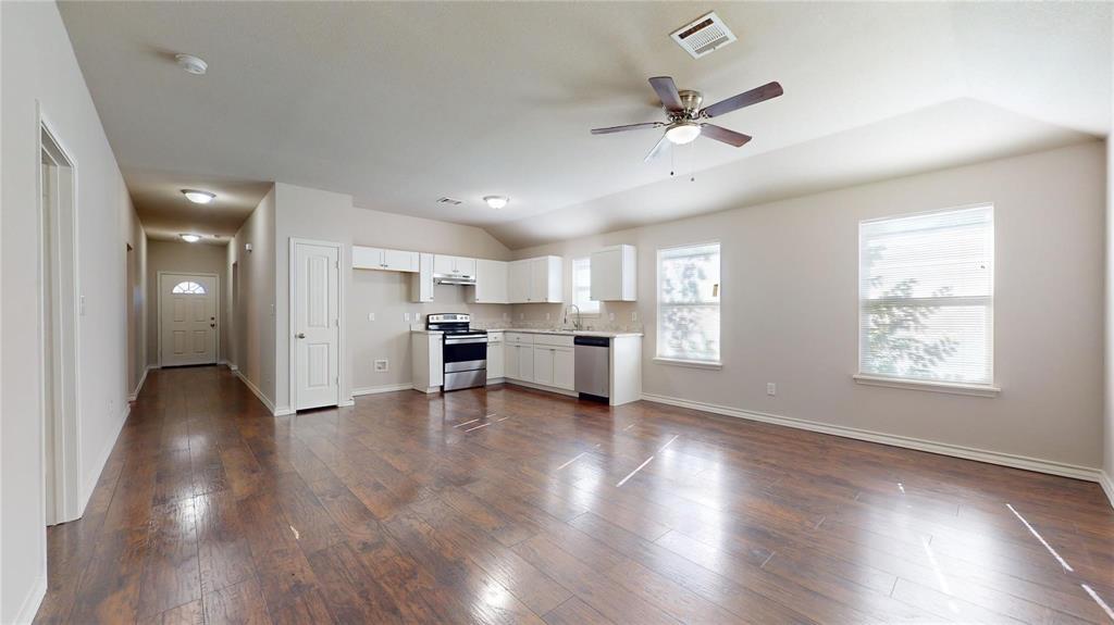 2104 Daniel Street Fort Worth, TX 76104 - Photo 5 of 12 Unfurnished living room featuring a ceiling fan, dark wood-style flooring, and vaulted ceiling